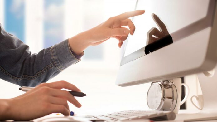 Las manos de una persona señalando un ordenador